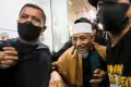Senyuman Petinggi Khilafatul Muslimin Abdul Qadir Baraja saat Tiba di Polda Metro Jaya